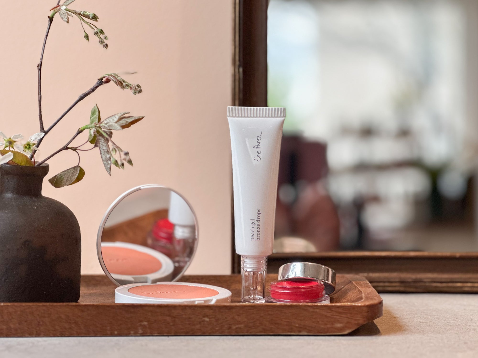 Cosmetic products on a wooden tray with a blurred background